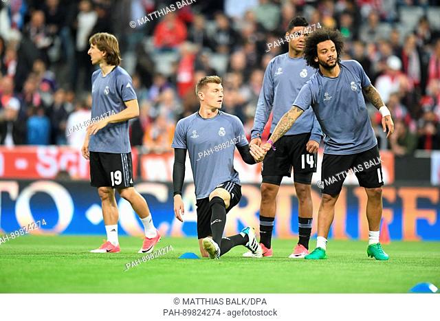 Real Madrid's Toni Kroos (C) warms up with teammates ahead of the first leg of the Champions League quarter final match between Bayern Munich and Real Madrid in...