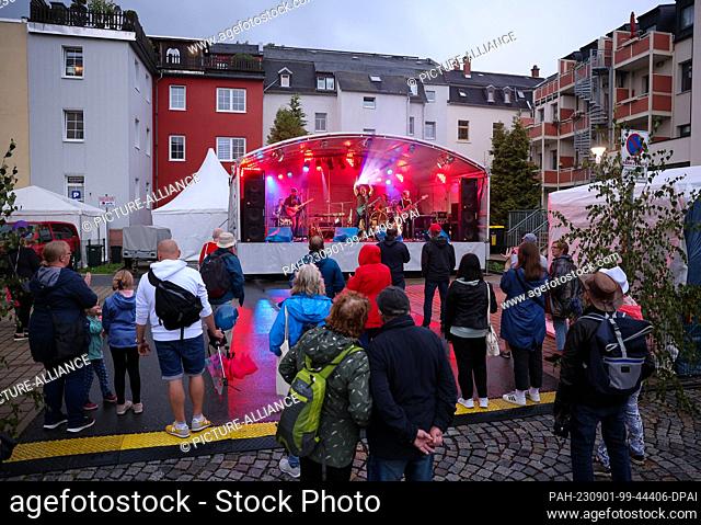 01 September 2023, Saxony, Aue-Bad Schlema: Numerous visitors brave the rain at the performance of the band Sedony with ex-Puhdy Peter Meyer at the ""Day of...
