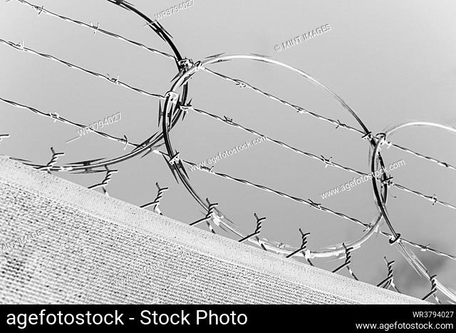 A barbed wire fence and draped frabric