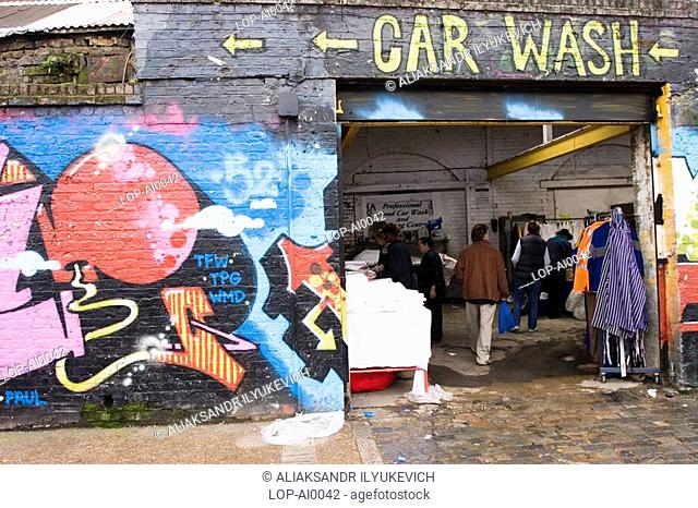 England, London, London, East End Market with graffiti. The word 'graffiti' is the plural of 'graffito' and originates from the Italian word 'graffiato' which...