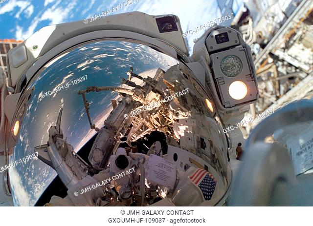 Astronaut Garrett Reisman, Expedition 16 flight engineer, uses a digital camera to expose a photo of his helmet visor during the mission's first scheduled...