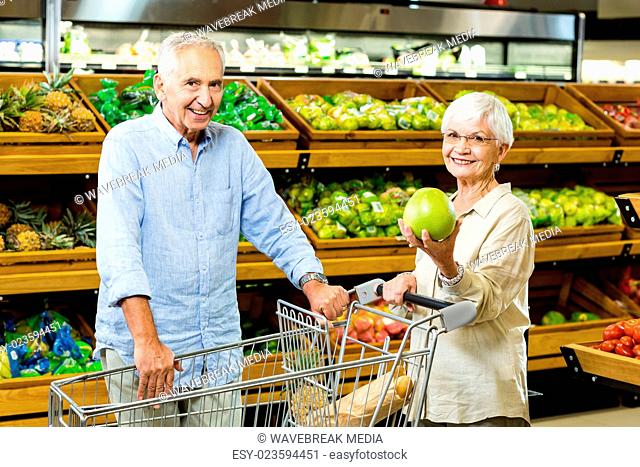 Senior couple showing a fruit