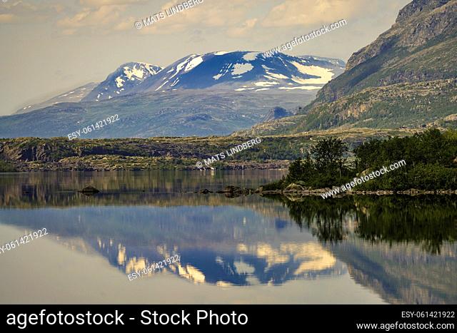 Stor sjöfallet national park in summer time with nice sunny weather, mountain reflecting in Lule river, still snow on top of the mountains
