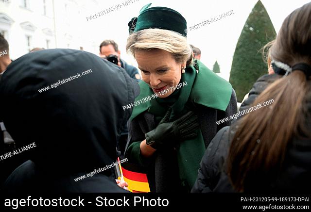 05 December 2023, Berlin: Queen Mathilde of Belgium speaks to children from a school class during a welcome with military honors at Bellevue Palace as part of...