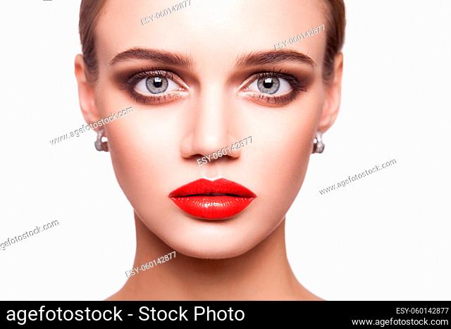 Portrait of beautiful young brunette woman with smoky eyes makeup and red lips looking at camera. beauty, makeup health and skin care concept