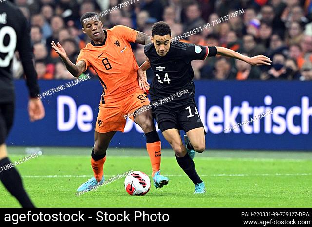 29 March 2022, Netherlands, Amsterdam: Soccer: Internationals, Netherlands - Germany, Johann Cruyff ArenA. Germany's Jamal Musiala (r) and the Netherlands'...