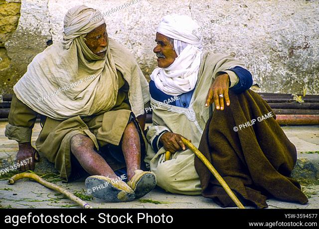 Two elderly men enjoy a chat in a quiet street of Douz, Tunisia, a date-growing oasis town on the edge of the Sahara