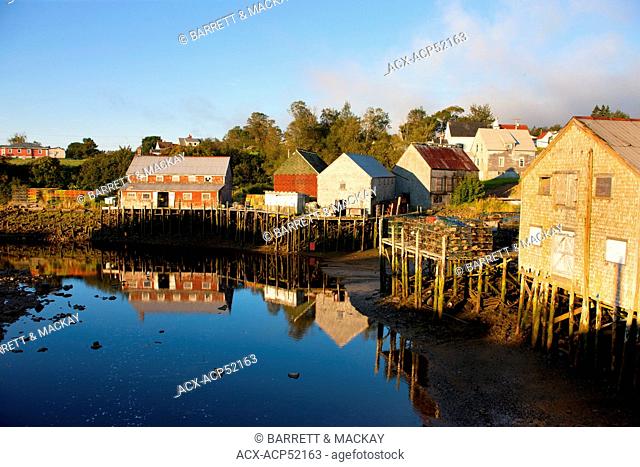 Fishing shed reflected in harbour at low tide, Seal Cove, Grand Manan Island, Bay of Fundy, New Brunswick, Canada