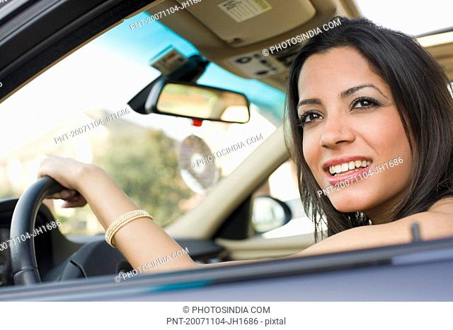 Close-up of a young woman smiling in a car