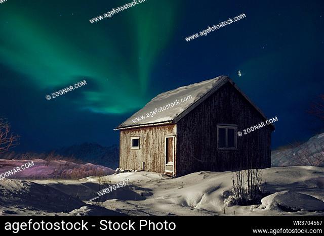 Aurora borealis Green northern lights above mountains on the Lofoten islands, Norway. Night sky with polar lights. Night winter landscape with aurora