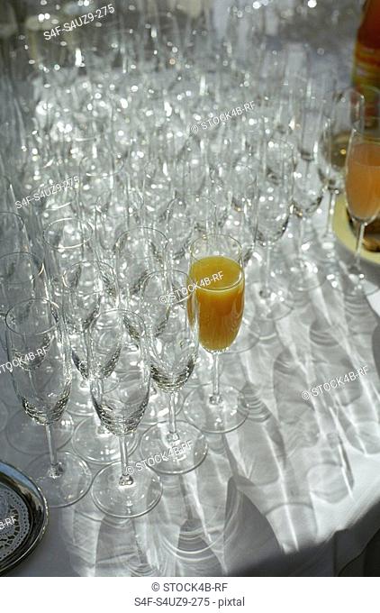 Two Champagne Glasses filled with Juice amongst empty Glasses - Contrast - Structure - Beverages
