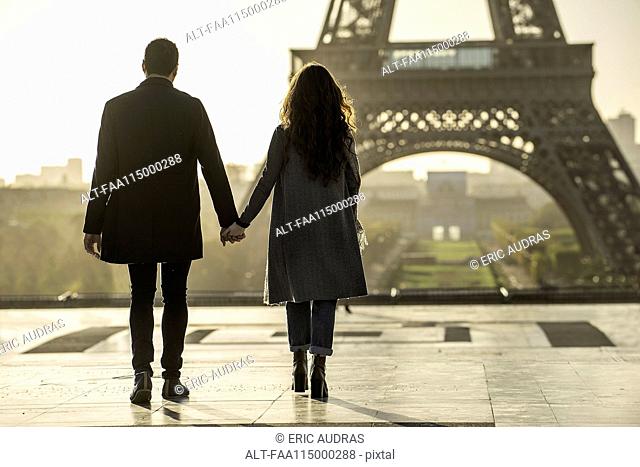 Couple holding hands near Eiffel Tower