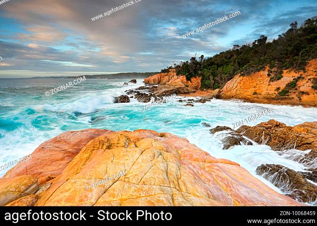 Bermagui coastline, with beautiful peach and apricot colours in the sandstone and aqua blue waters