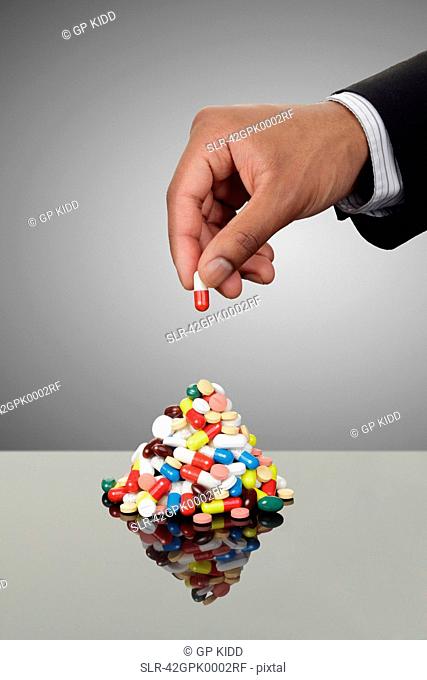 Businessman stacking pills on counter