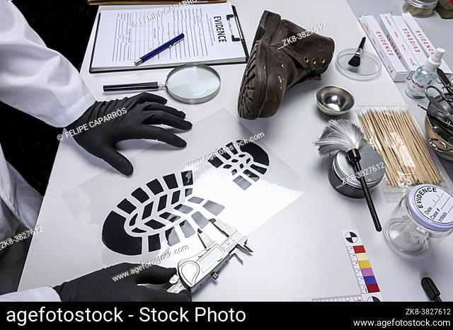 Police scientist investigates with a scale on a shoe sole tape tread involved in crime lab murder, concept image