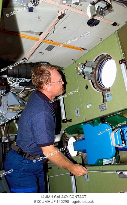 Astronaut Andrew S.W. Thomas looks through a window on the Zvezda Service Module soon after joining the rest of the STS-114 for its first joint visit with the...