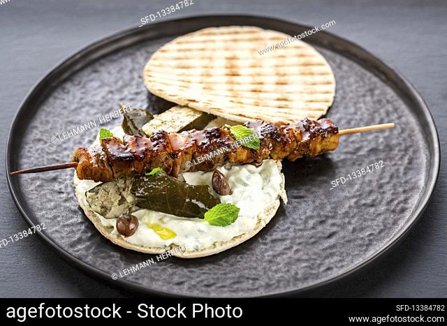 Greek pita bread filled with meat skewer and tzatziki