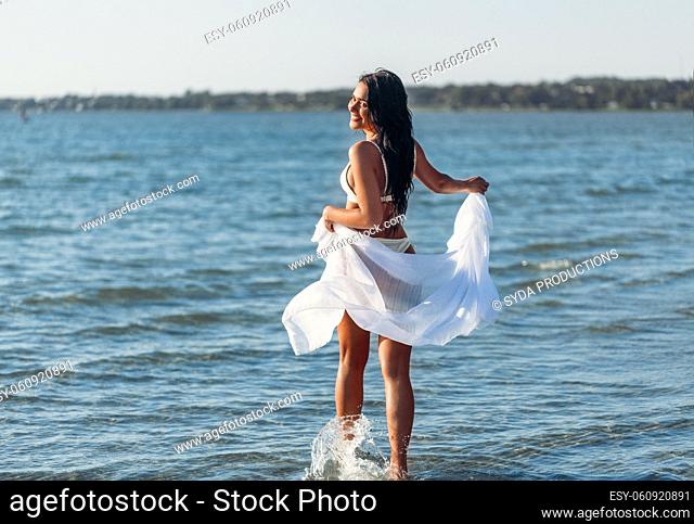 woman in bikini swimsuit with pareo on beach