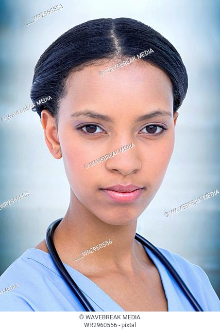 Close up of female doctor against blurry blue background