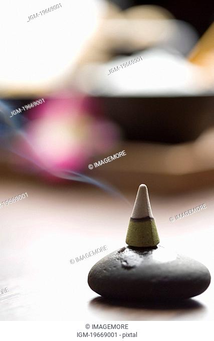 Cone of incense burning on lastone