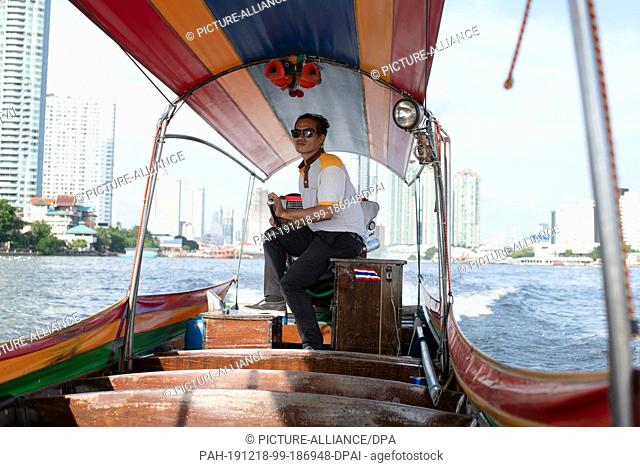 14 October 2019, Thailand, Bangkok: A man steers a longtail boat on the Chao Phraya. Photo: Sebastian Kahnert/dpa-Zentralbild