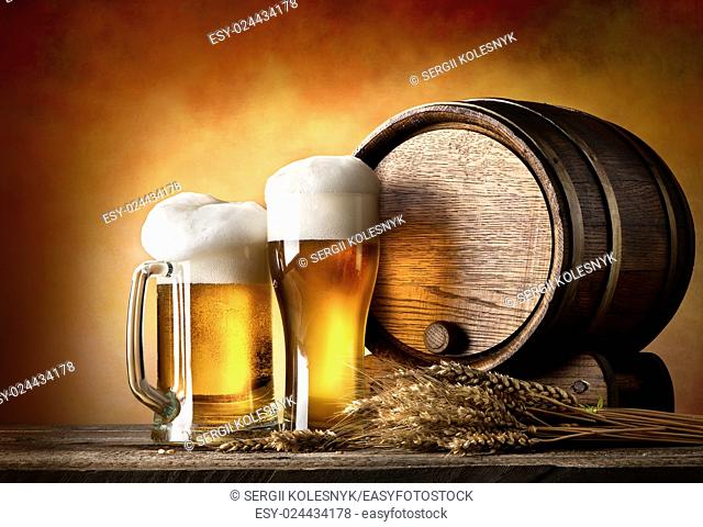 Beer with wheat and barrel on a wooden table