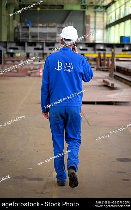 19 August 2021, Hamburg: A shipyard worker walks through a currently unused work hall. The situation of the insolvent shipyard Pella Sietas is very serious