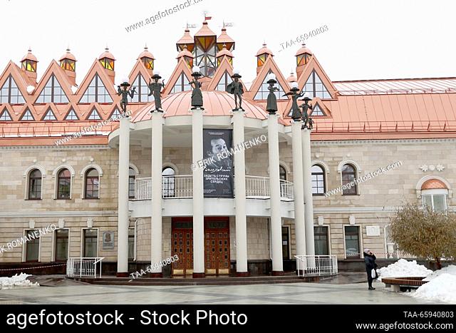 RUSSIA, VORONEZH - 20 de diciembre de 2023: Una mujer se encuentra ante el Teatro Voronezh State Puppet Theatre nombrado por el actor y director ruso Valery...