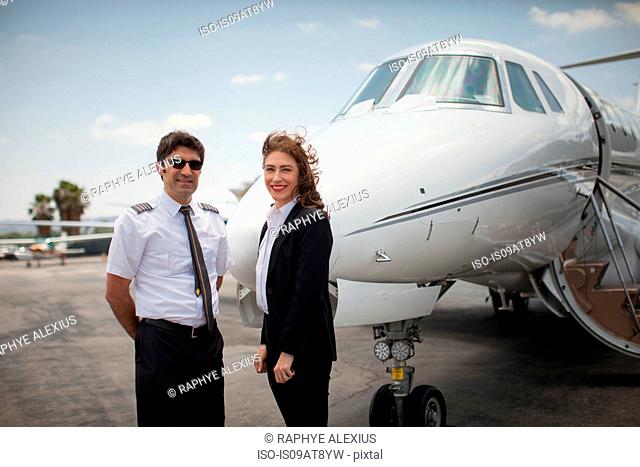 Portrait of female businesswoman and pilot of private jet at airport