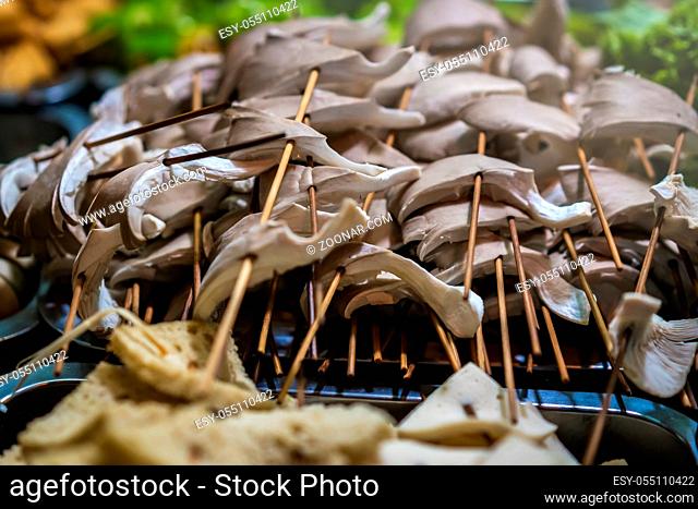 Freshly cut mushrooms on wooden sticks, ready to be grilled on the street in the Muslim Quarter, Xian town, China