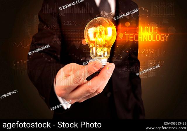 Businessman holding lightbulb with CLOUD TECHNOLOGY inscription, Business technology concept