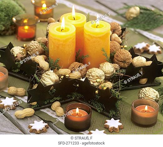 Star-shaped bowl decorated with nuts, fir sprigs and candles