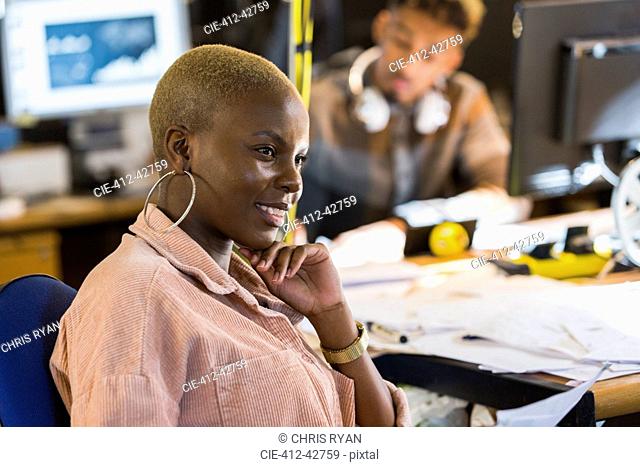 Smiling creative businesswoman working in office