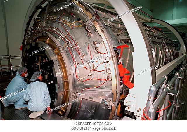 11/18/1998 -- Workers peer through the hatch of an end-cone on the U.S. laboratory module, an element of the International Space Station