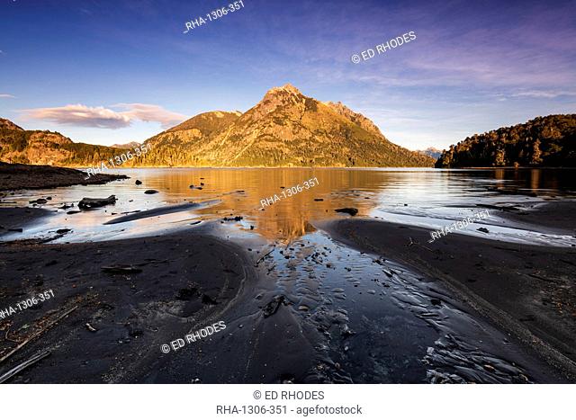 The black lava beach with reflected mountain, Bariloche, Patagonia, Argentina, South America