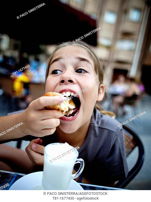 Girl eating in an outdoor café