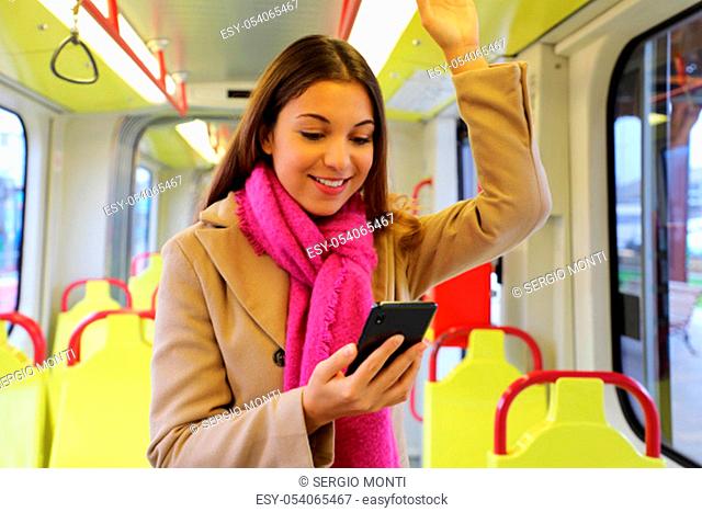 People on public transport. Beautiful young woman reading message on mobile phone on the tram