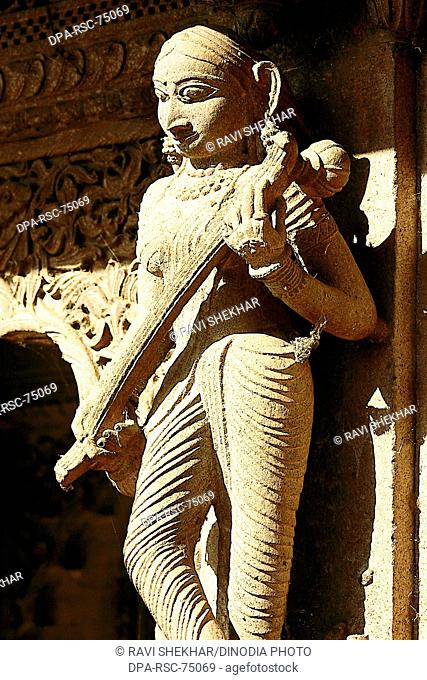 Indian musician , woman playing Veena , carved on wall of Ahilayabai temple , ornamental carving on stone , old Indian sculpture , Heritage site