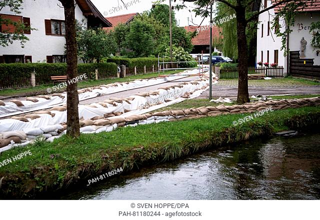 Sand bags seen on a street at the shore of the Tiefenbach stream in the centre of Polling, Germany, 13 June 2016. New heavy rainfall has prevented an...