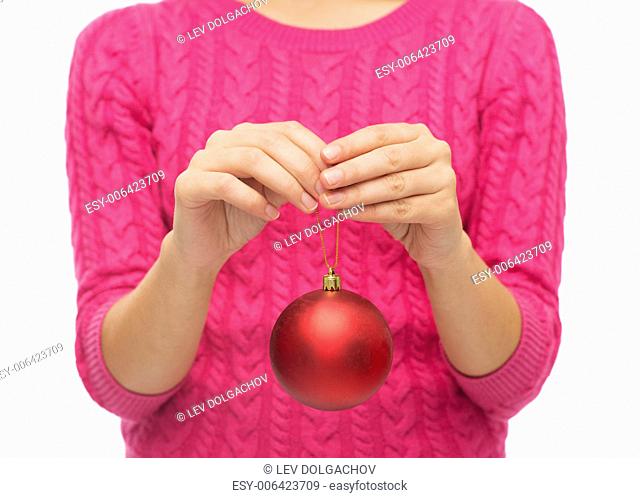 christmas, decoration, holidays and people concept - close up of woman in pink sweater holding christmas ball