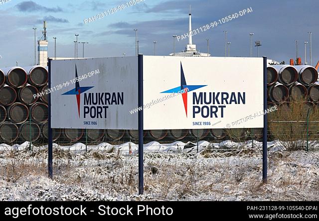 28 November 2023, Mecklenburg-Western Pomerania, Sassnitz: The port of Mukran on the Baltic Sea island of Rügen with a large sign reading ""Mukran Port""; pipes...