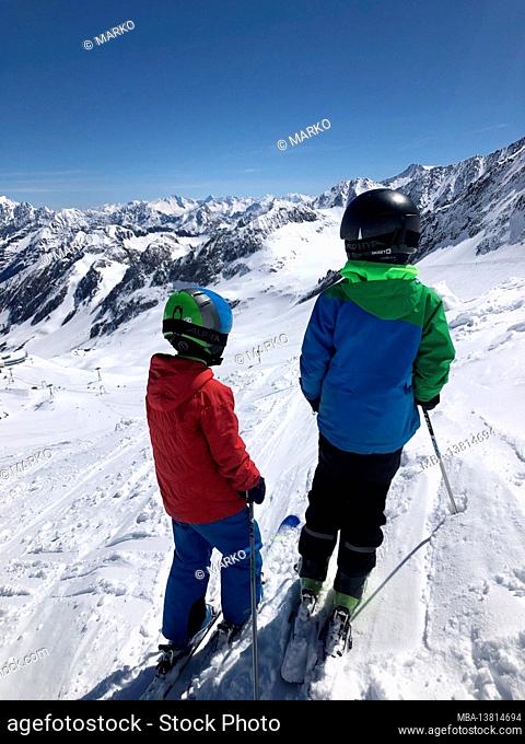 Ski area Stubai Glacier, two skier children from behind, Stubai Glacier Railway, panoramic view, winter landscape, skiing area, mountains, Mutterberg Valley