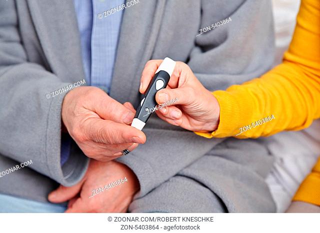 Hände bei der Blutzuckermessung bei einem Patienten mit Diabetes mellitus