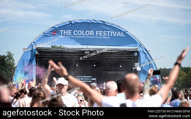 30 July 2022, North Rhine-Westphalia, Neuss: Visitors dance to the music. The ""Farbgefühle"" festival, also known as the ""Holi Festival of Colours