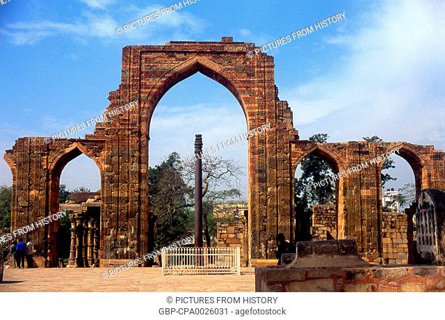India: The remains of the Quwwat-ul-Islam Mosque and in the foreground the almost 2, 000 year old Iron Pillar at the Qutb Minar complex, Delhi