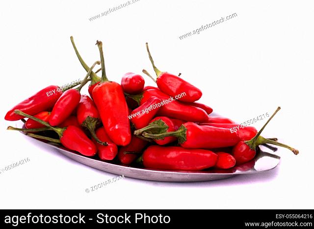 Detail view of a bunch of red chili peppers scattered isolated on a white background