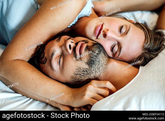 Young couple sleeping together at home