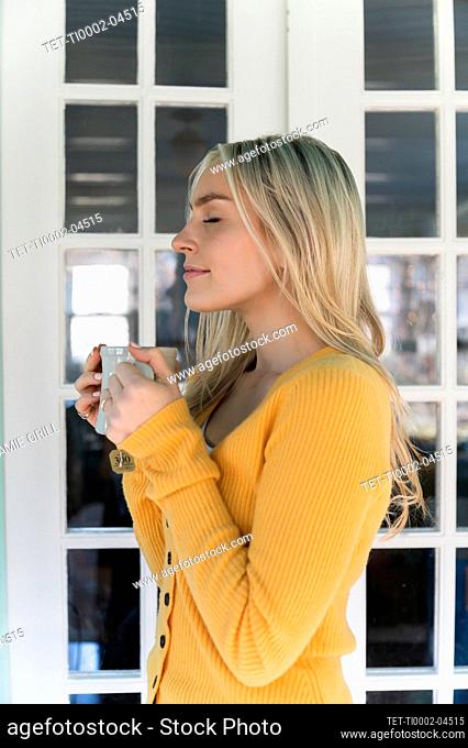 Portrait of woman in yellow sweater holding mug