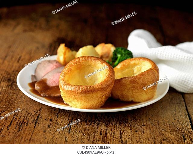Plate of roast beef, yorkshire puddings, broccoli and potatoes