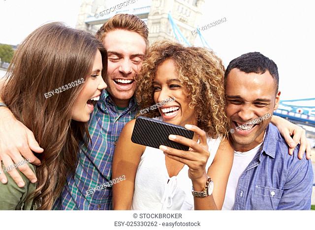 Group Of Friends Taking Selfie By Tower Bridge In London
